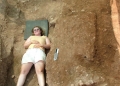 Angela lying next to the cover slab of a Geometric sarcophagus.