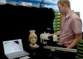Mark Abbe examining an acrolithic head of Sarapis from the South Stoa with a microscope.